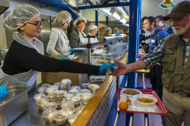 Andrew Medichini / AP Photo Homem recebe sorvete durante almoço no centro de ajuda aos necessitados Caritas, em Roma.