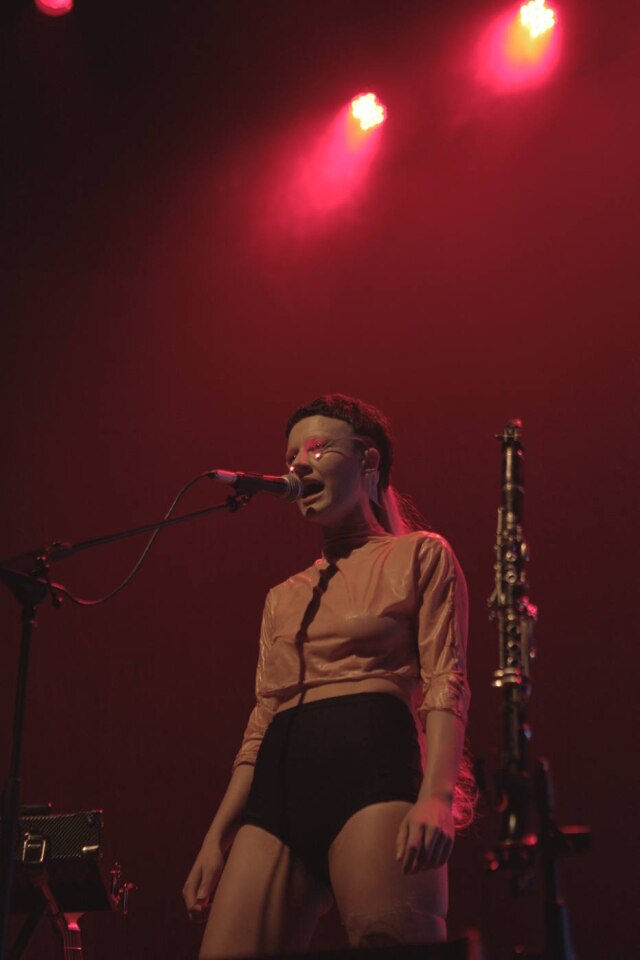 Aline Belfort/Divulgação No show de 'Cavala', Maria Beraldo usa hot pants, blusa de látex, botas Dr. Martens e uma crina presa aos cabelos