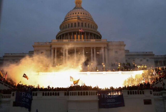 Leah Millis/ Reuters Explosão causada por uma munição policial é vista enquanto apoiadores de Donald Trump se reúnem em frente ao Capitólio dos EUA