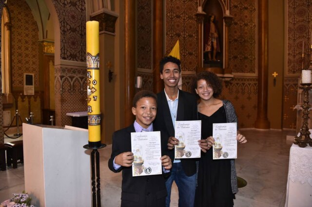David Harrad/Arquivo Pessoal Os irmãos adotivos Filipe (esquerda), Alyson (centro) e Jéssica (direita), batizados na catedral de Curitiba.