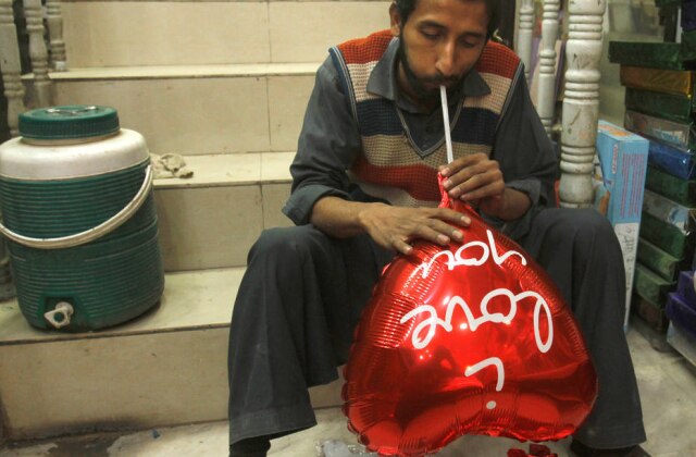 Fayaz Aziz / Reuters Homem enche balão para o Valentine's Day em Peshawar, no Paquistão