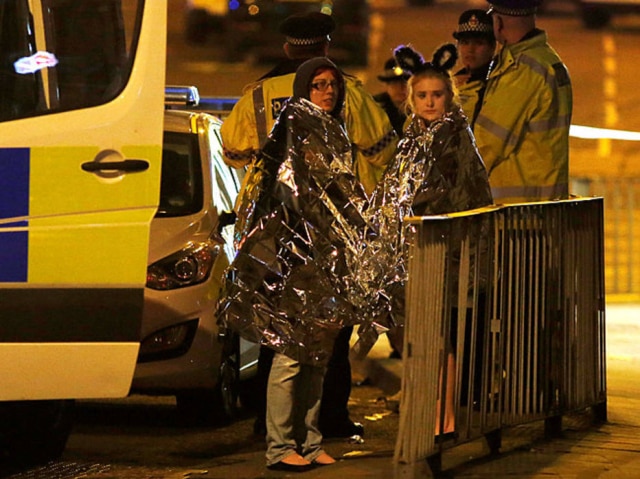 REUTERS/Andrew Yates Duas fãs enroladas em capas térmicas após explosão em show de Ariana Grande