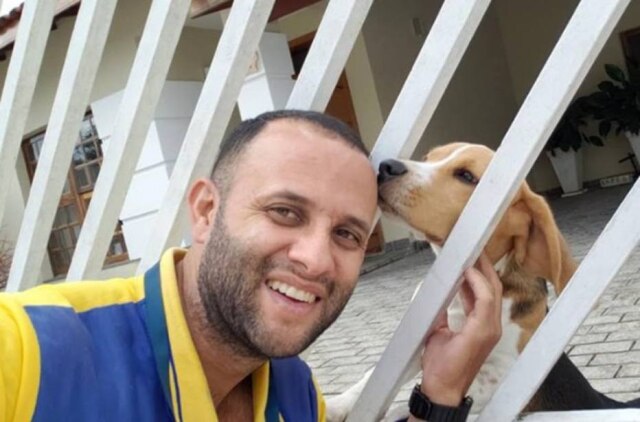 Facebook/angelocristianodasilvaantunes/ Carteiro faz sucesso com fotos ao lado de cachorros.