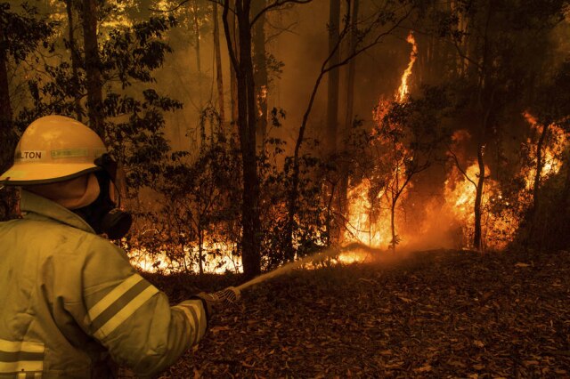 Matthew Abbott / The New York Times Bombeiro combate incêndio em floresta de Tomerong, em Nova Gales do Sul, na Austrália.