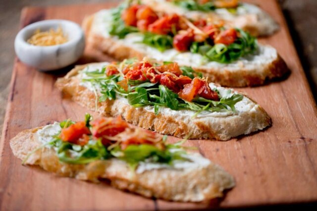 Rikki Snyde/NYT Torrada com tomate assado e queijo feta.