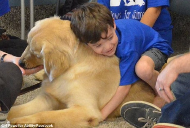 Reprodução/Facebook/DailyMail Menino autista abraçando seu cachorro.