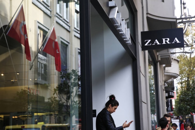 AP Photo/Lefteris Pitarakis Clientes encontram etiquetas em roupas na Zara, em Istambul, que diziam: 'Eu fiz este item que você irá comprar, mas não fui pago por isso'