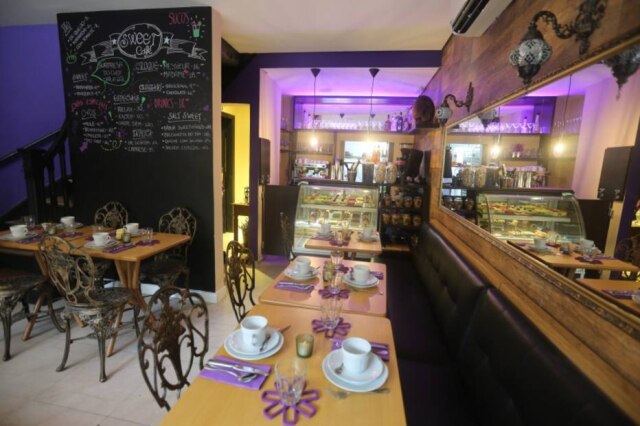 Nilton Fukuda|Estadão Ambiente do novo café do confeiteiro Arnor Porto, com a vitrine de doces ao fundo.