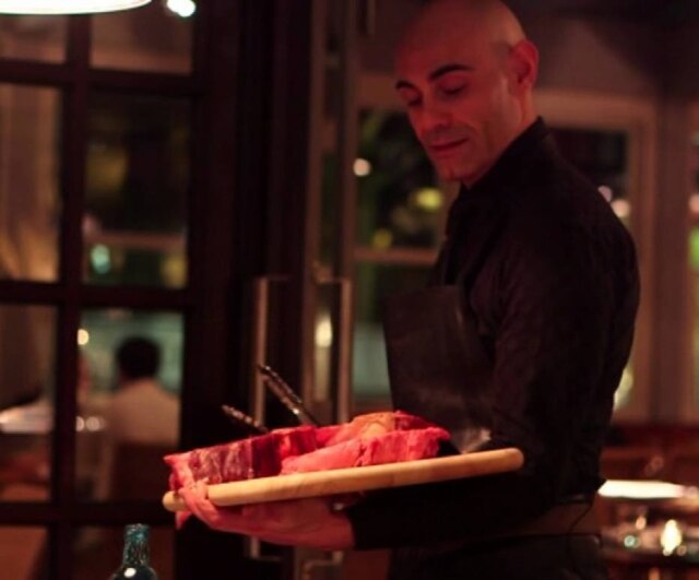 Divulgação Abastante em serviço, oferecendo peças de carne a cliente