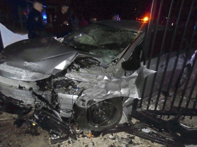 Hopkinton Police Department via AP Carro não conseguiu fazer uma curva, atingiu a parede externa da casa e depois ricocheteou no portão.