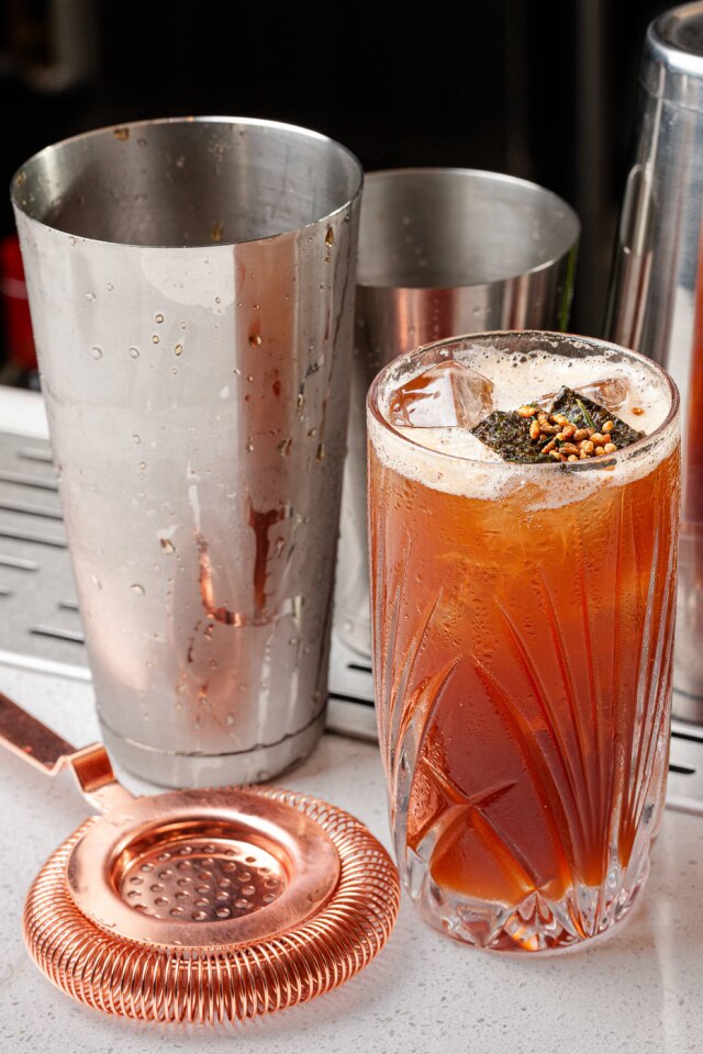 Dhani Borges Camarote Carril. Gim, infusão de abacaxi grelhado, amaro Lucano, Cynar, xarope de genmaicha, limão e ginger ale, do novíssimo Spirit Bar