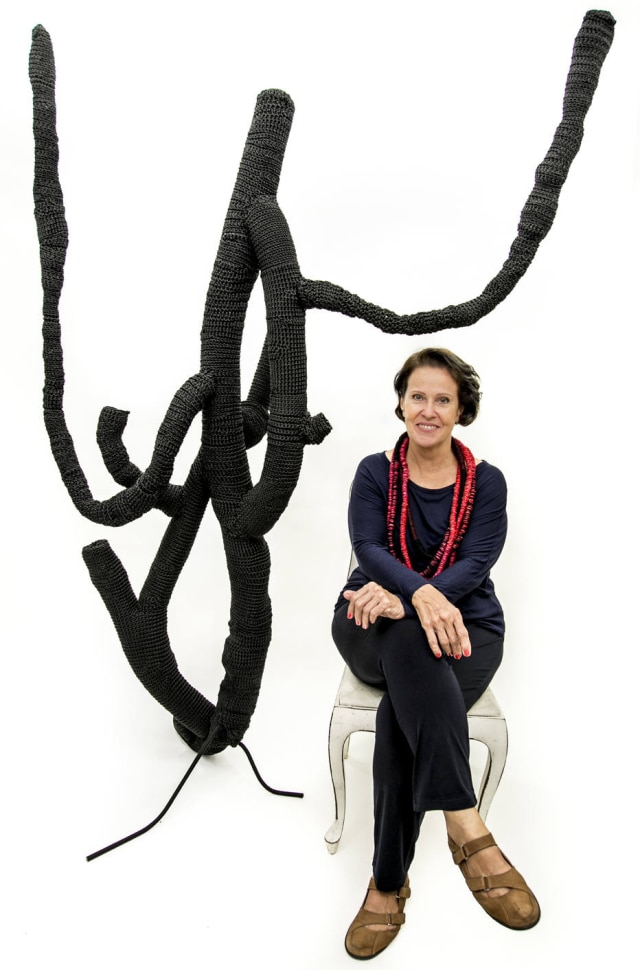 Divulgação A artista em meio às formas têxteis criadas para a exposição Flores Negra