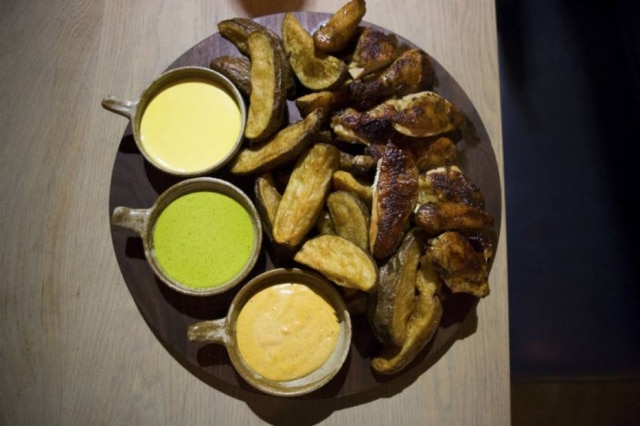 Cassandra Giraldo|The New York Times Para compartilhar. Frango assado em pedaços e fritas com molhos do Llama Inn
