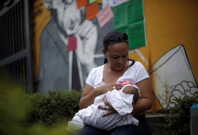 Juan Carlos Ulate/Reuters Mulher amamenta o bebê durante celebração da Semana Mundial do Aleitamento Materno na Costa Rica.