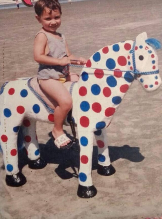 arquivo pessoal Leandro Gomez brinca com cavalo colorido na infância