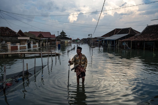 Aji Styawan / Getty Images Climate Visuals Grant Recipient Morador da cidade de Demak, na Indonésia, em meio a uma enchente