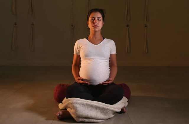 Marina Patari Garcia em postura de meditação. Pano sob os joelhos ajuda a equilibrar o peso do corpo entre eles e o quadril e aliviar a pressão no baixo ventre e na lombar.