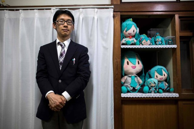 Behrouz Mehri / AFP Akihiko Kondo com várias bonecas em referência à sua 'esposa' virtual.
