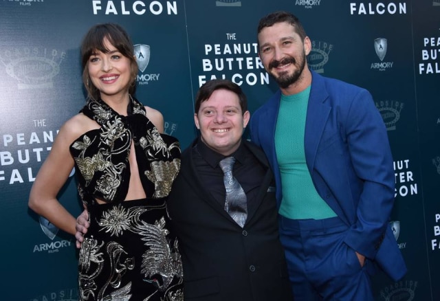 Chris Delmas/ AFP A atriz Dakota Johnson, o ator Zack Gottsagen e o ator Shia LaBeouf chegam para exibição especial do filme The Peanut Butter Falcon, em Hollywood