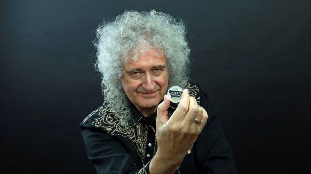 Cortesia Queen Productions LTD/ via Reuters Guitarrista Brian May da banda Queen com uma moeda cinco libras