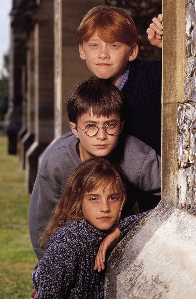 REUTERS/WARNER BROTHERS/Terry O'Neill Os atores da saga 'Harry Potter', Rupert Grint, que vive Ron Weasley; Daniel Radcliffe, que vive Harry Potter; e Emma Watson, que vive Hermione Granger, em cartaz de divulgação do primeiro filme 'Harry Potter e a Pedra Filosofal'.