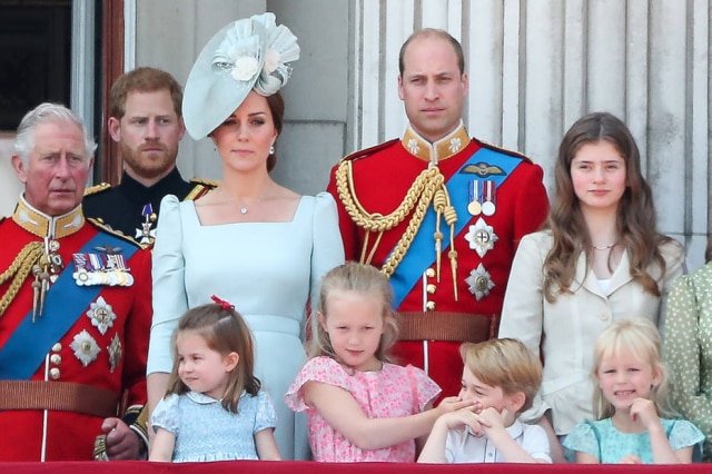AFP PHOTO / Daniel LEAL-OLIVAS Savannah Phillips, bisneta mais velha da rainha Elizabeth, tapa a boca do Príncipe George durante execução do Hino Nacional Britânico.