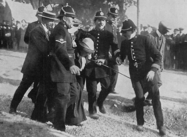 Policiais prendem sufragista durante protesto pelo direito feminino ao voto, Inglaterra, 1913.
