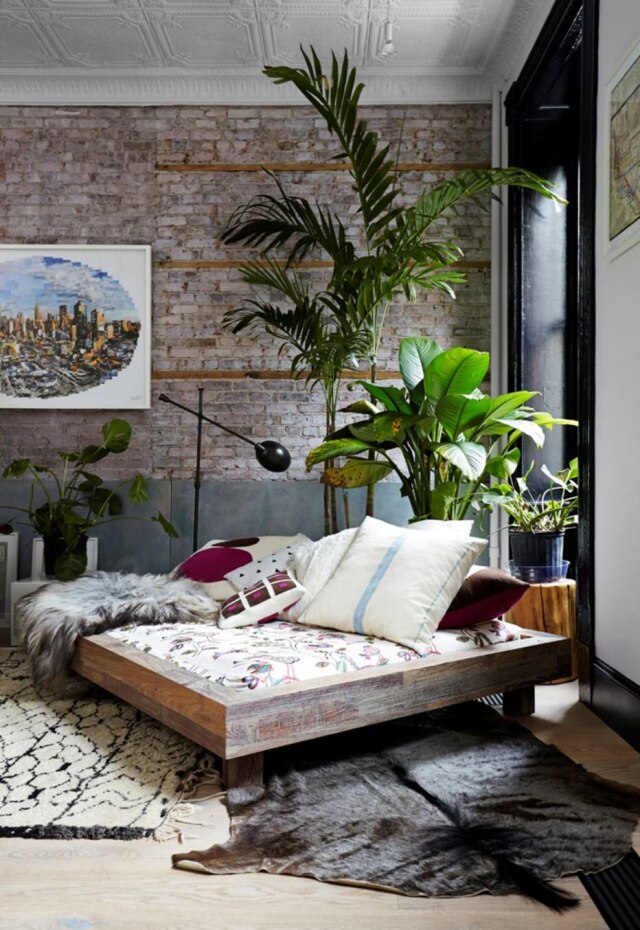 Laura Moss/The New York Times No living, sofá-cama de madeira de demolição cercado por plantas