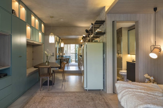 Evelyn Muller Apartamento ganhou iluminação pontual com lustre pendente e focos de luz nos nichos da estante