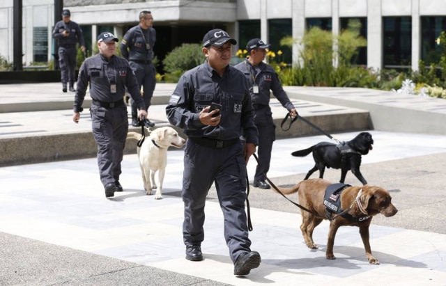 Canela e seu treinador chegando à cerimônia de aposentadoria de cães farejadores da polícia colombiana.