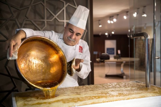 O confeiteiro Huseyin Aksoy, do Nar Gourmet, derrama a base do akide, tradicional doce feito desde o Império Otomano, em uma superfície de mármore para esfriar.