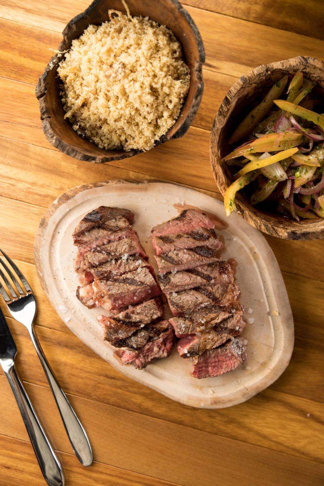 Henrique Peron Da grelha seam cortes como o ribeye, que chega acompanhado de farofa da casa um vinagrete com coentro, cebola roxa e tomate