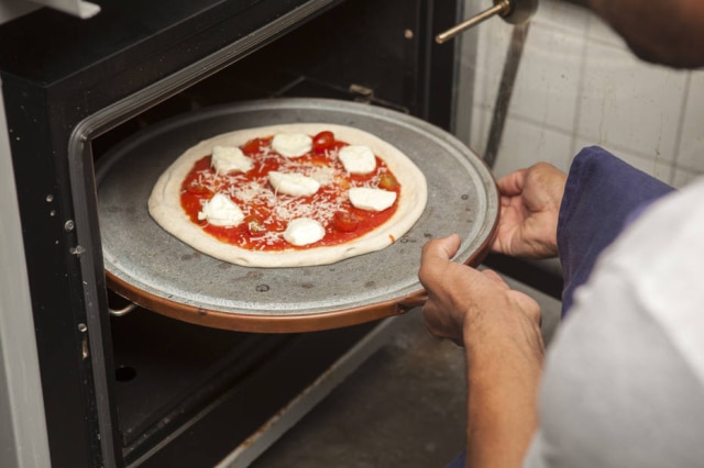 Na segunda vez ao forno, a pizza já vai como todos os ingredientes. 