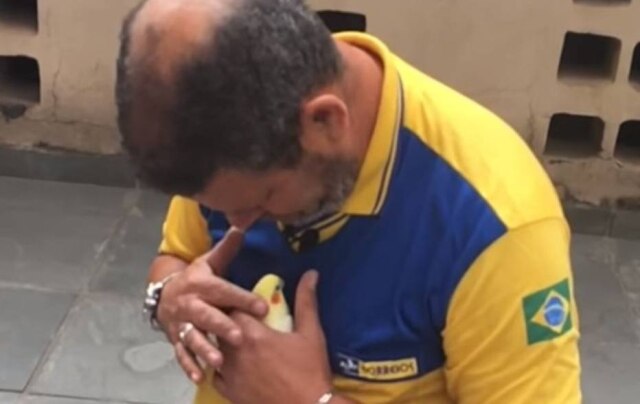 Divulgação/Correios A calopsita Sofia nos braços do carteiro Nelson.