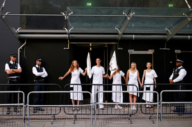 Henry Nicholls/Reuters Policiais fazem a segurança na entrada principal da Semana de Moda de Londres enquanto ativistas bloqueiam a passagem.