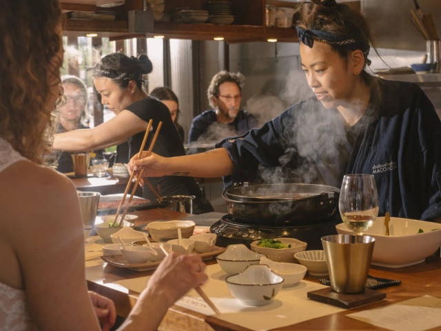 Cole Wilson/NYT Mako Okano serve shabu-shabu seguindo o ritual: os legumes e as finas fatias de carne são mergulhadas em caldo fumegante feito à base de alga kombu e depois, um por vez, no molho ponzu.