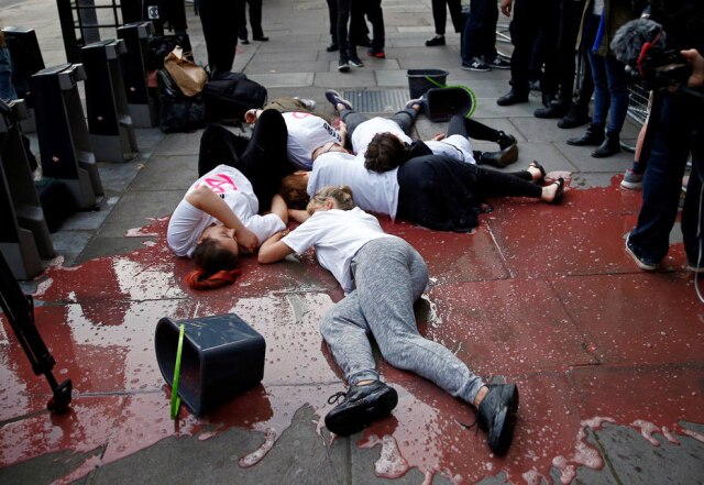 Henry Nicholls/Reuters Ativistas deitaram em poça de tinta que faz referência a sangue durante a Semana de Moda de Londres.