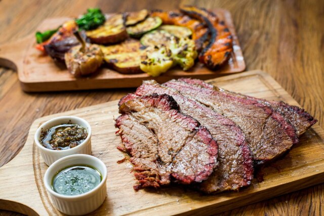 Tiago Queiroz/Estadão Prove. Brisket, o peito bovino defumado por longas horas no pit, com legumes na brasa