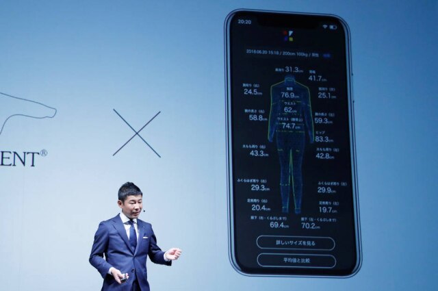 Kim Kyung-Hoon/Reuters Yusaku Maezawa, presidente da Zozo, apresenta o sistema de medição corporal tecnológica de sua marca de roupas sob medida