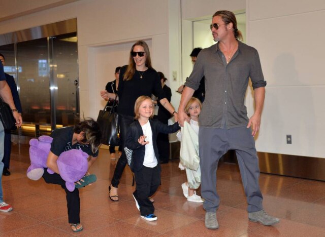 Yoshikazu Tsuno/AFP Angelina Jolie e Brad Pitt, em julho de 2013, com três dos seis filhos no aeroporto de Tóquio.