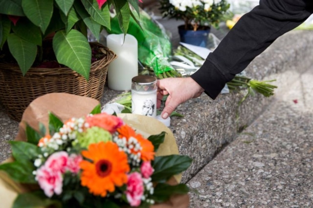 Cyril Zingaro|EFE Velas e flores são deixadas em frente ao restaurante Hôtel de Ville.