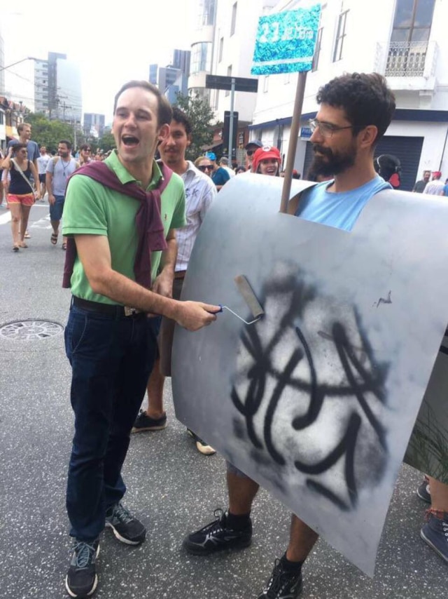 https://www.facebook.com/alutaonline/ Foliões fantasiados de João Doria e muro cinza