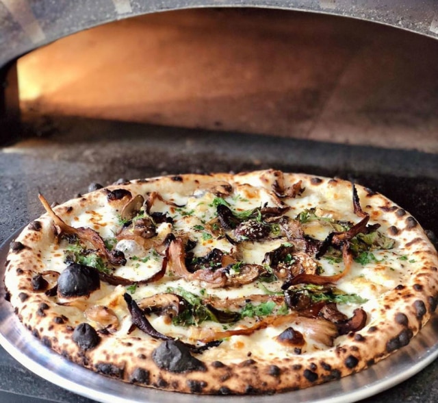 Lupita Pizza de mussarela, taleggio, grana padano, cogumelos assados e creme de limão e alho.