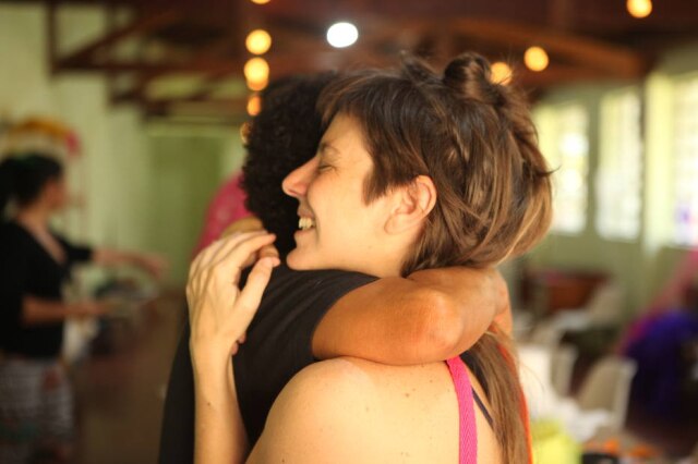 Divulgação Relação com pacientes com transtornos mentais vai além da psiquiatria: carinho, amor, empatia e inserção social ajudam no tratamento terapêutico. Na foto, a coordenadora do setor educativo do evento, Flávia Mielnik, sorridente, abraça uma usuária do Centro de Apoio Psicossocial.