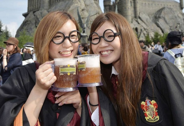 Kyodo / Reuters Jovens à frente de uma atração sobre o universo de 'Harry Potter' em parque da Universal Studios Japan, em Osaka, em 2014.