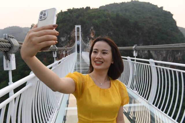 Nhac NGUYEN / AFP Visitante tira uma selfie na ponte de vidro Bach Long, no Vietnã, que tem capacidade máxima de até 450 pessoas por vez.